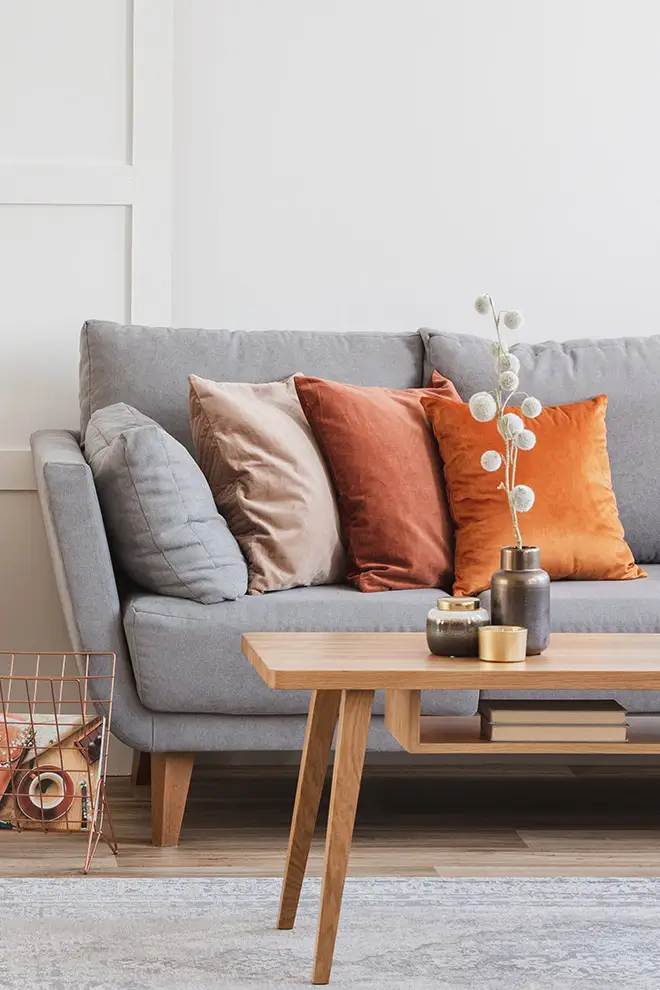 D-Lux Möbel – Textilien und Stoffe Ein graues Sofa mit bunten Kissen aus Samt