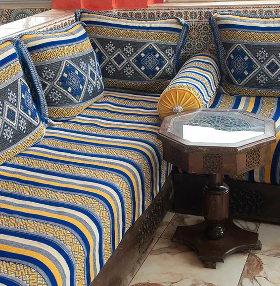 in Blau, Gold und Elfenbein gemustertes Plaid auf einer Couch mit Kissen