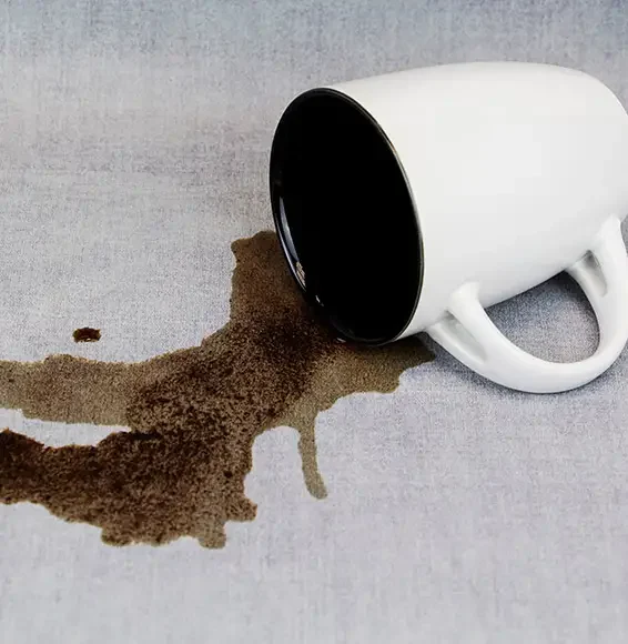 Verschüttetes Getränk auf einem grauen Baumwollbezug