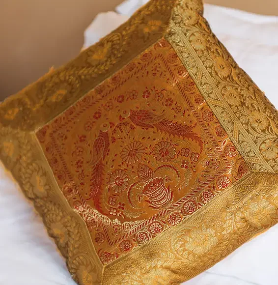 Goldenes mit Mustern besticktes Kissen