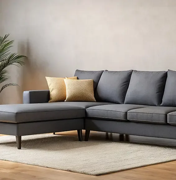 Dunkelgraue Couch mit Kissen vor heller Wand